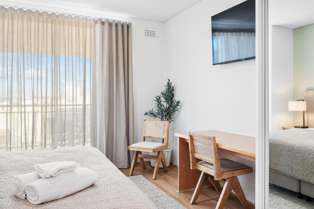 a bedroom with a desk and a bed and a table at Cityscape Haven CBD Apartment with Balcony in Perth