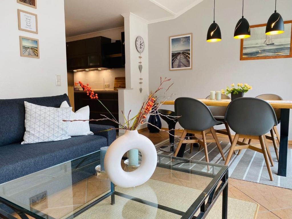 a living room with a blue couch and a table at Birkennest in Zingst