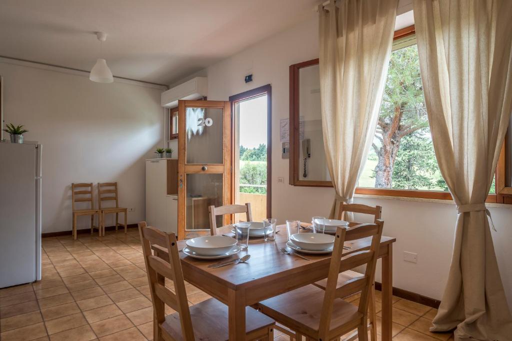 comedor con mesa, sillas y ventana en Caletta Apartments, en Castiglioncello