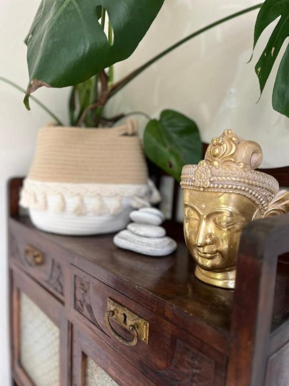 a table with a gold head vase and a plant at Iliodromi - The Sun Path Retreat in Vourliótai