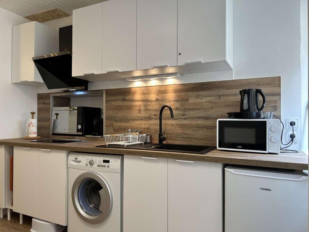 une cuisine avec un lave-linge et un micro-ondes dans l'établissement Appartement T2 à Banyuls, calme et proche plage - FR-1-225C-170, à Banyuls-sur-Mer