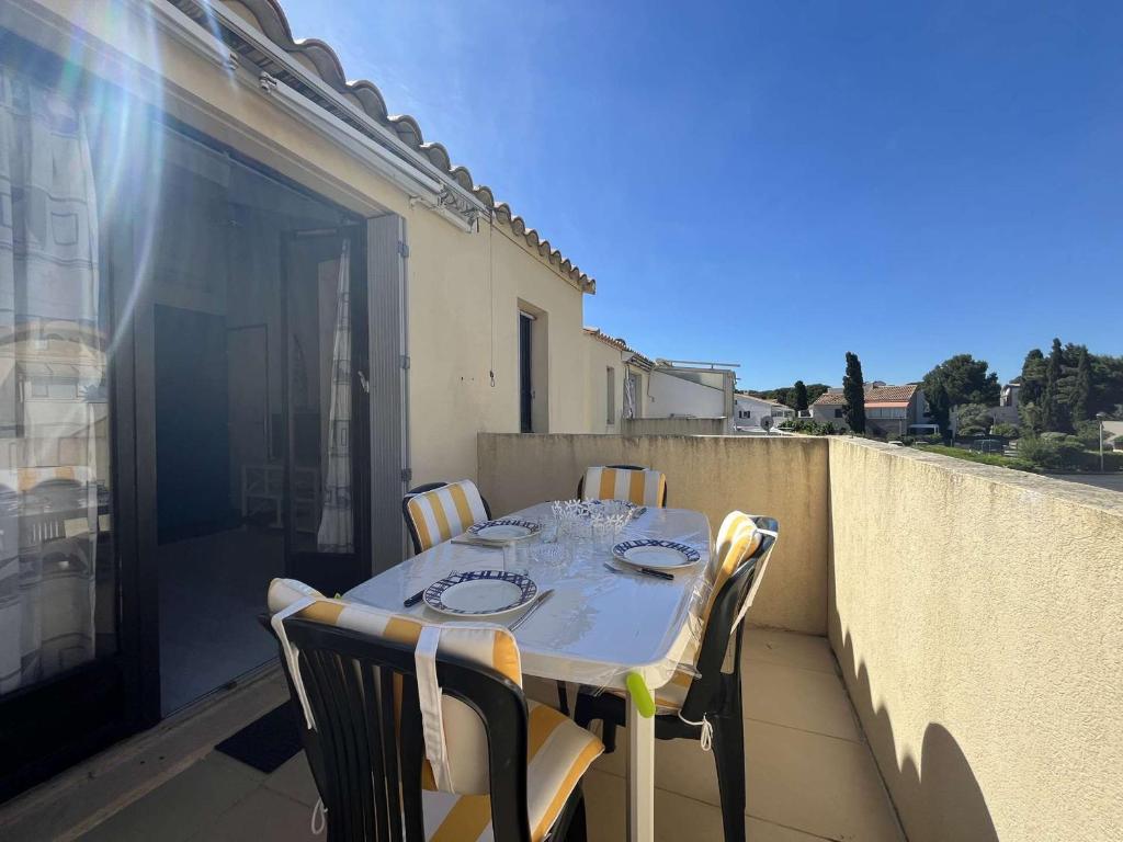 une table et des chaises sur un balcon avec vue dans l'établissement Appartement 2 pièces climatisé avec parking - Gruissan - FR-1-229-898, à Gruissan