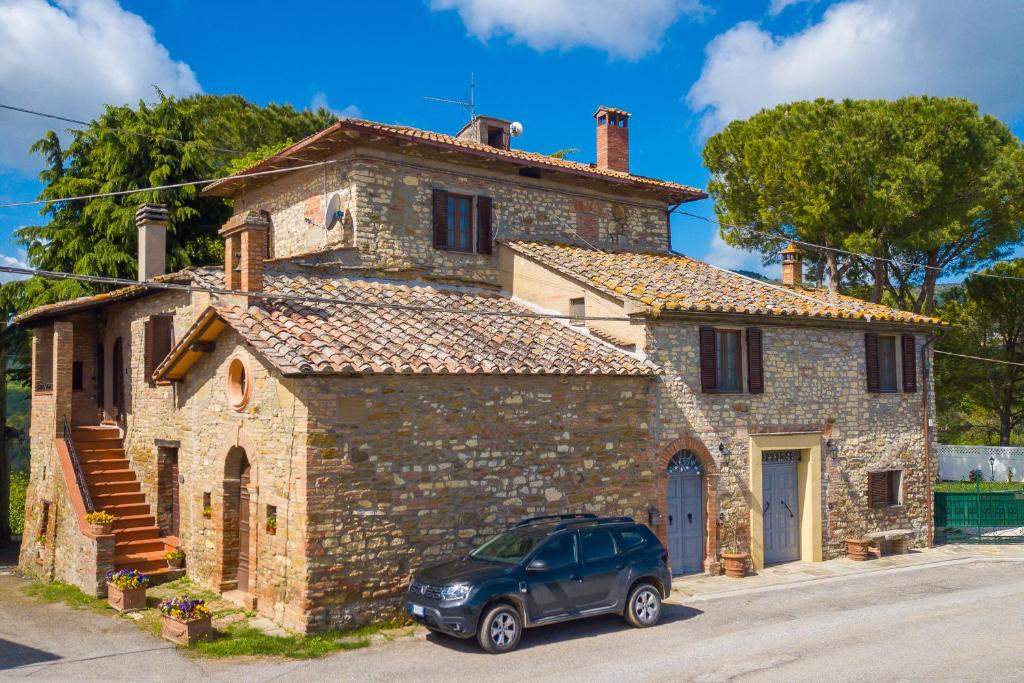 a car parked in front of a stone house at Borgo Panicale with Shared Pool and Garden in Panicale