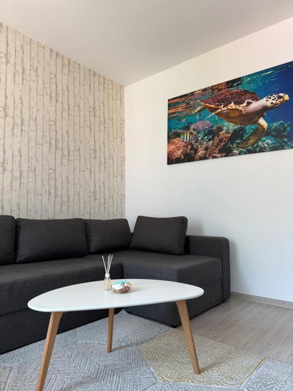 a living room with a couch and a table at Lira Holiday Apartments in Eforie Nord