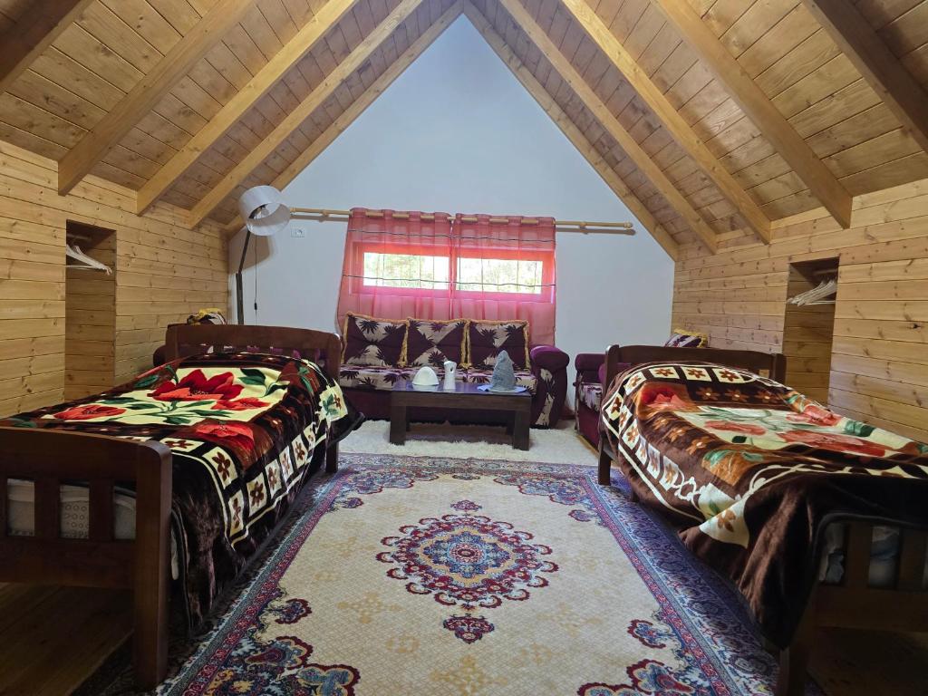 a living room with two beds and a table at Guesthouse Lika in Shkozë