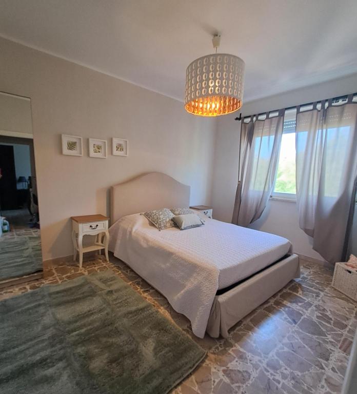 a bedroom with a bed and a chandelier at Vistamare in Marina di Cecina