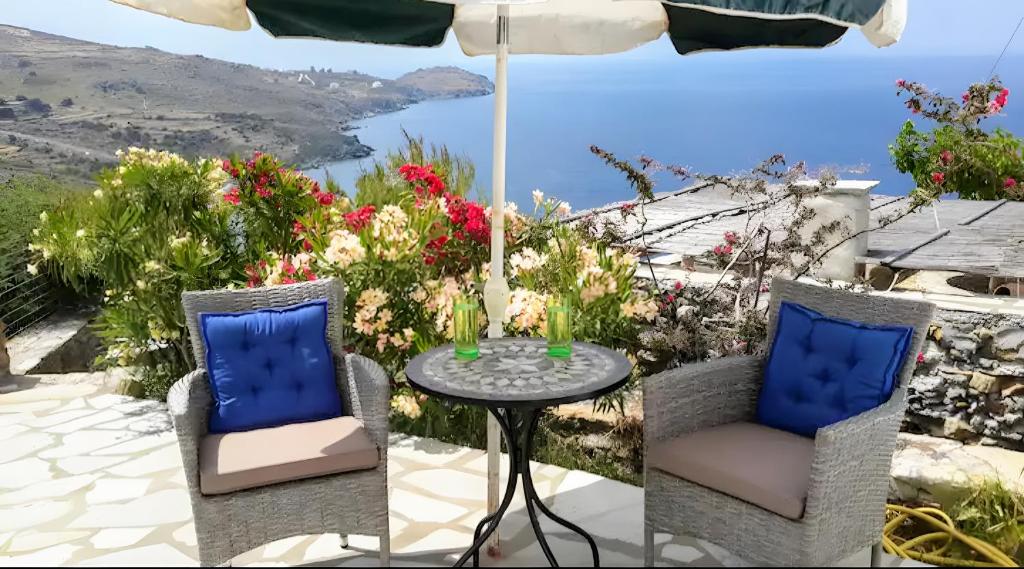 a table and chairs with a view of the ocean at Dove View in Andros