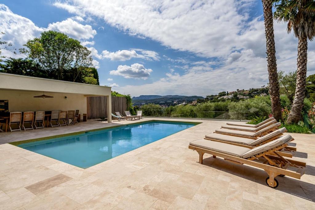 Una piscina con tumbonas y una casa. en Grande Bastide, Cassis, en Cassis