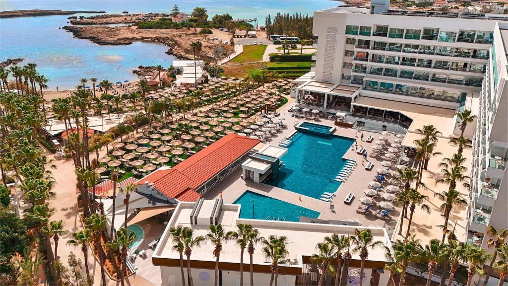 an aerial view of a resort with a pool and a beach at Cavo Maris Beach Hotel in Protaras