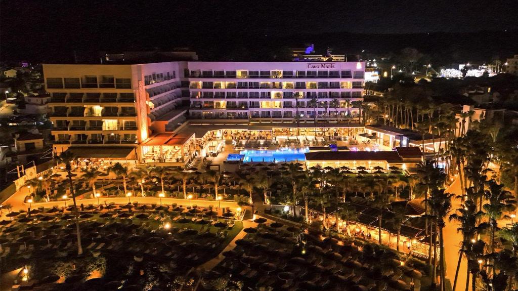a large building with a courtyard at night at Cavo Maris Beach Hotel in Protaras