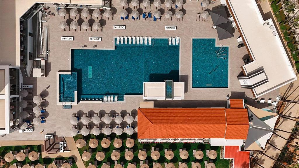 an aerial view of a swimming pool and a building at Cavo Maris Beach Hotel in Protaras