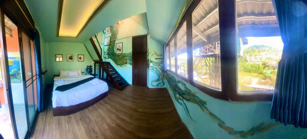 a bedroom with a bed in a room with windows at Valley Yurt rakthai วอลเล่ย์ เยิร์ท รักไทย in Ban Nong Chaeng