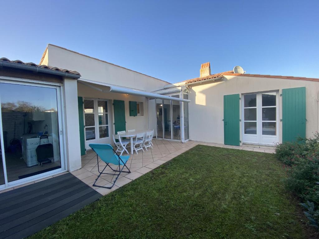 d'une terrasse avec des chaises et une table dans la cour. dans l'établissement La maison des Boutons d Or, à Sainte-Marie de Ré