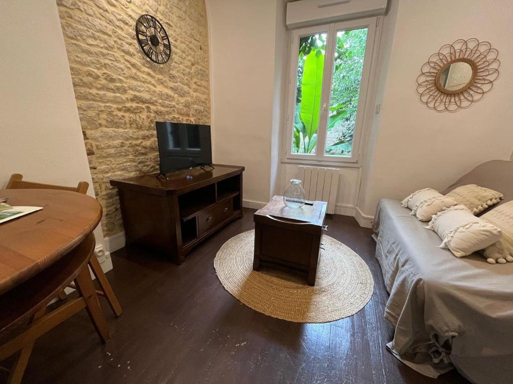 - un salon avec un lit, une télévision et une table dans l'établissement Le Poitevin Garden View Center31, à Niort