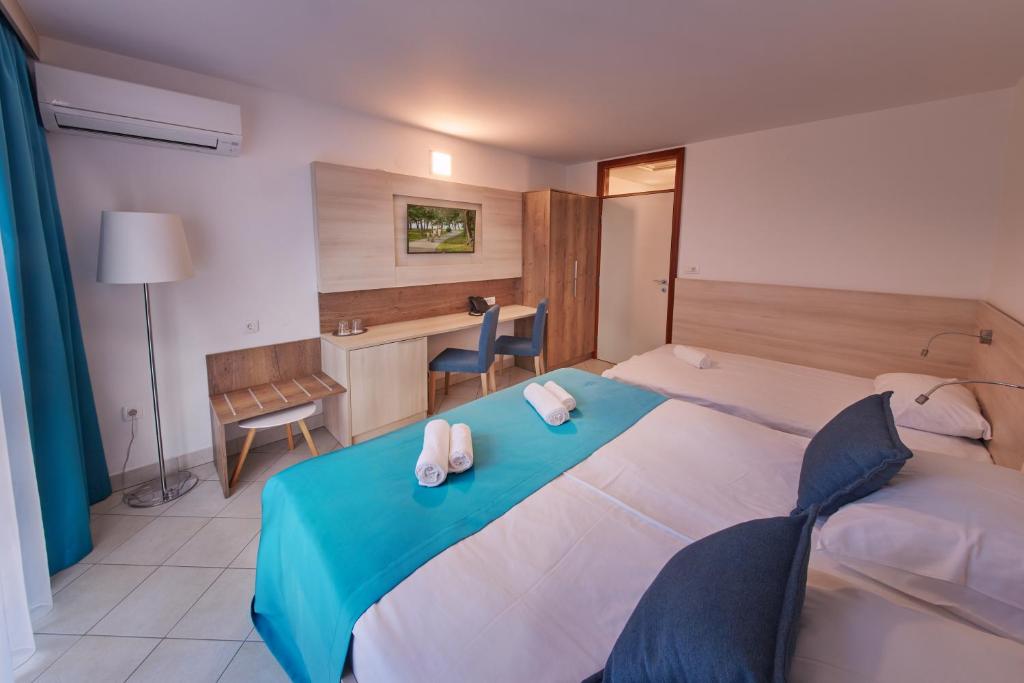 a bedroom with a large bed with two towels on it at Villas - Hotel & Resort Adria Ankaran in Ankaran