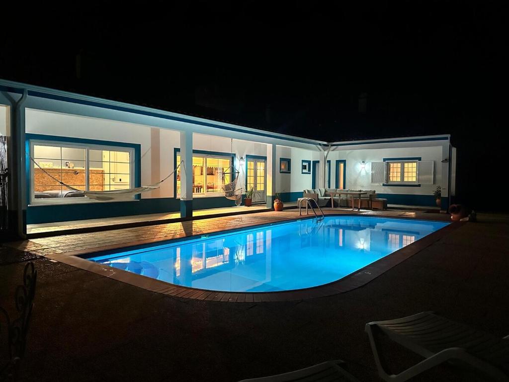 a large swimming pool in a house at night at Villa Rio in Praia do Ribatejo