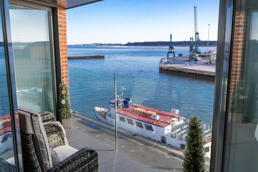 een balkon met uitzicht op een boot in het water bij Dolce Vita - Duplex Apartment with Incredible Harbour Views in Poole