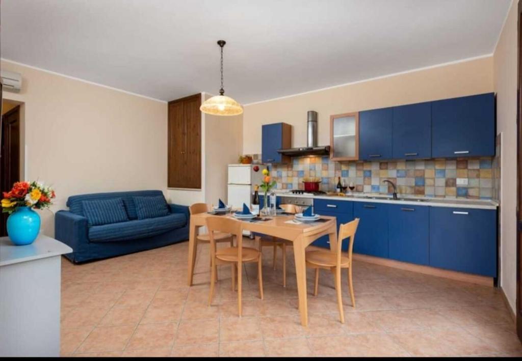 a kitchen and dining room with a table and blue cabinets at SanVitoTour - Covo deI Pirati in San Vito lo Capo