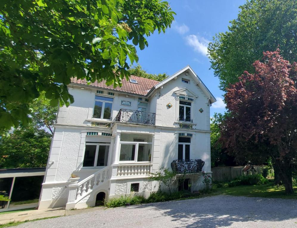 une maison blanche avec un balcon dans une rue dans l'établissement La Villa Madeleine -jacuzzi - 10 voyageurs, à Calais