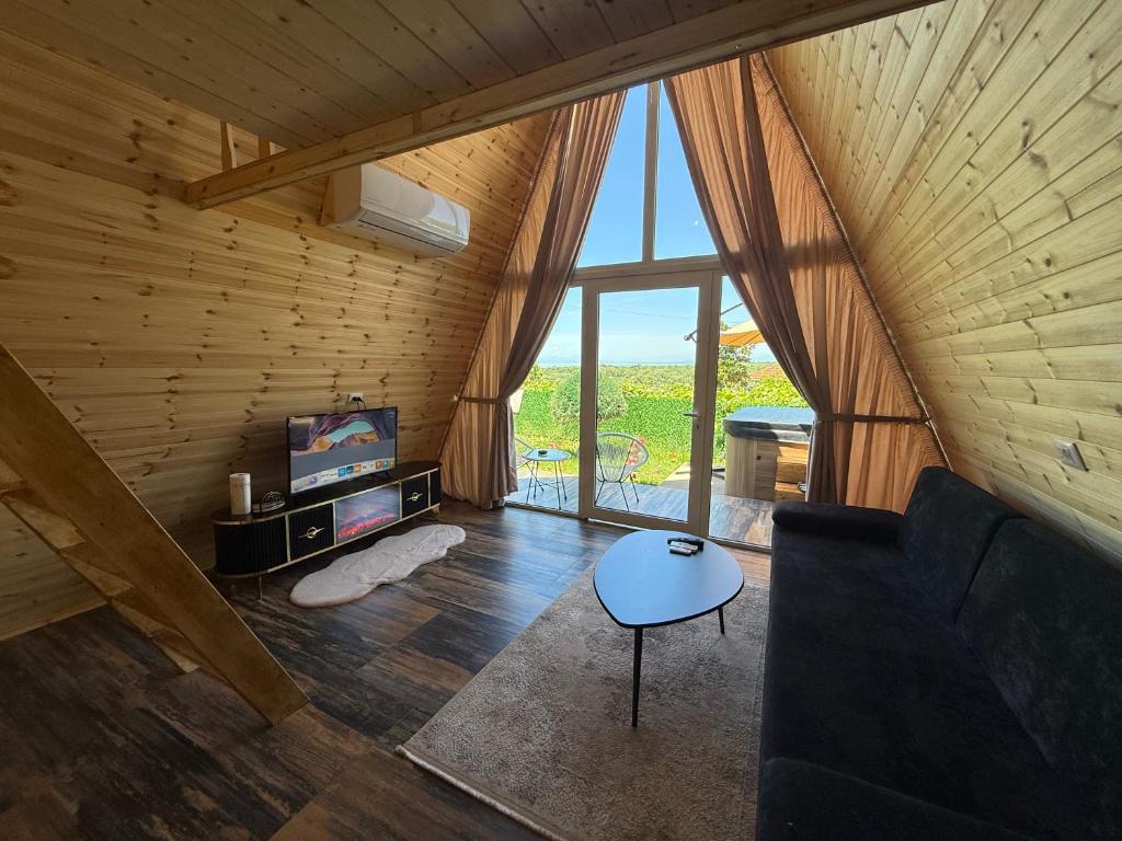 een woonkamer met een bank en een televisie op zolder bij Alex's House Shirokë in Shkodër