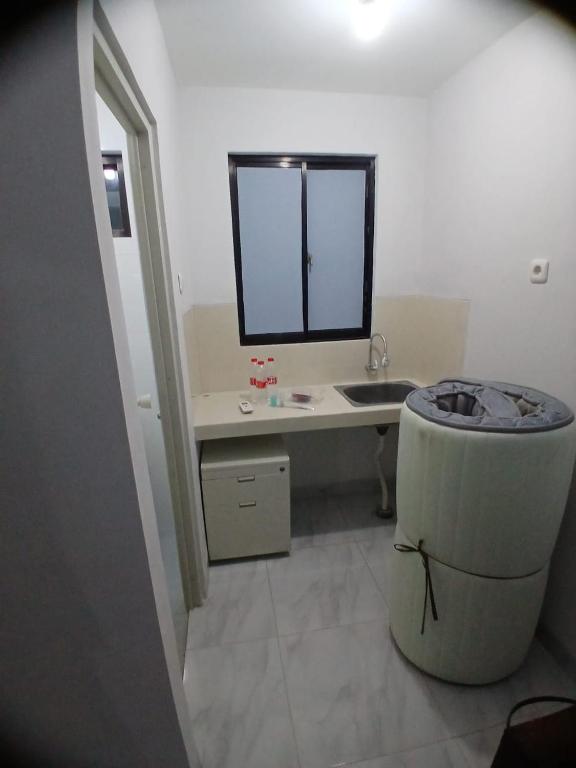 a bathroom with a sink and a desk with a mirror at Kamar Kost AC Mezanine in Gombong