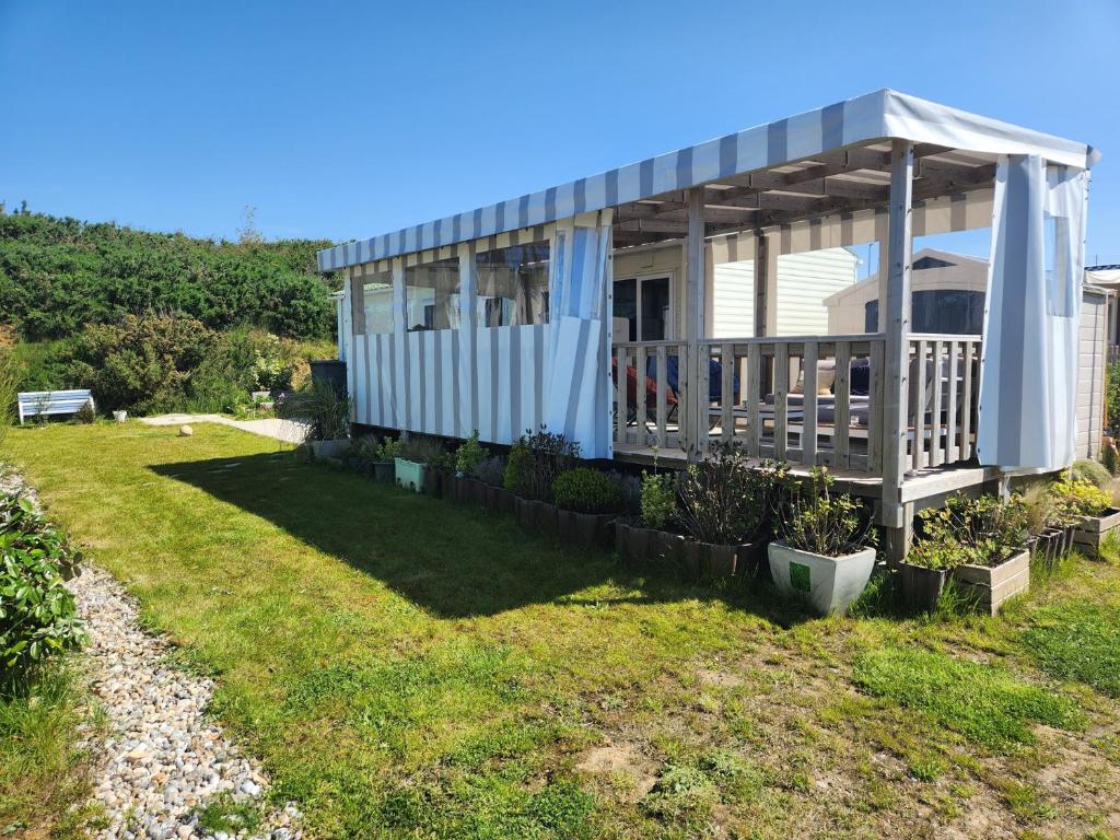 a house with a porch with an umbrella at MOBILHOME camping LA FALAISE in Équihen-Plage