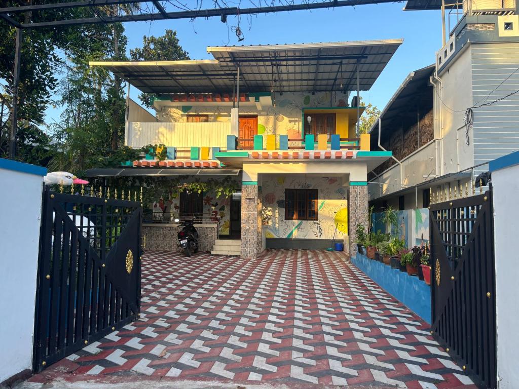 a house with a black gate and a driveway at Cozy Glick in Varkala
