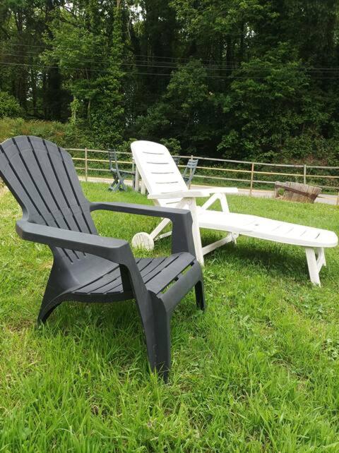 deux chaises noires et blanches assises dans l'herbe dans l'établissement Ti Guernevez - Le Cottage, à Briec