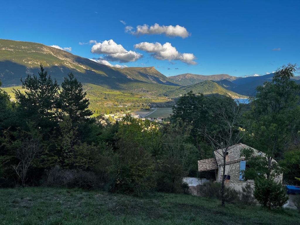 une maison sur une colline avec des montagnes en arrière-plan dans l'établissement Authentique cabanon provençal, à Saint-André-les-Alpes