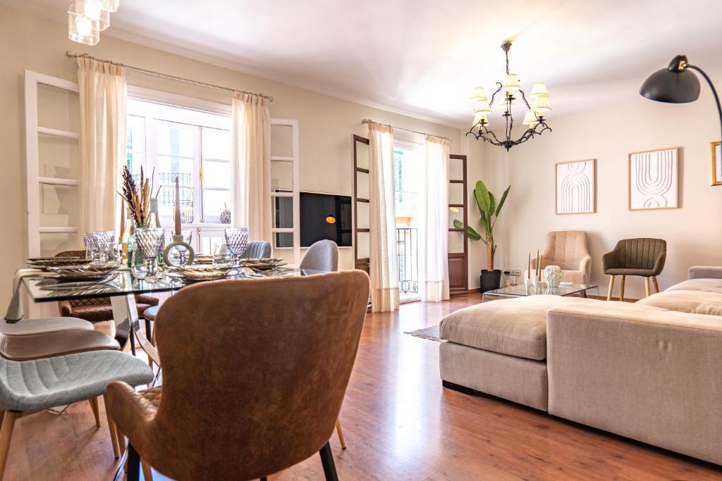 Hotel Málaga Down Town, a living room with a dining table and a couch at Málaga Down Town in Málaga