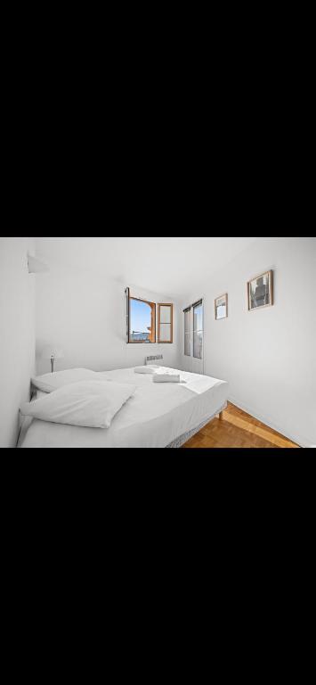 une chambre blanche avec un grand lit et un miroir dans l'établissement Superbe 2 Pièces avec balcons !, à Nice