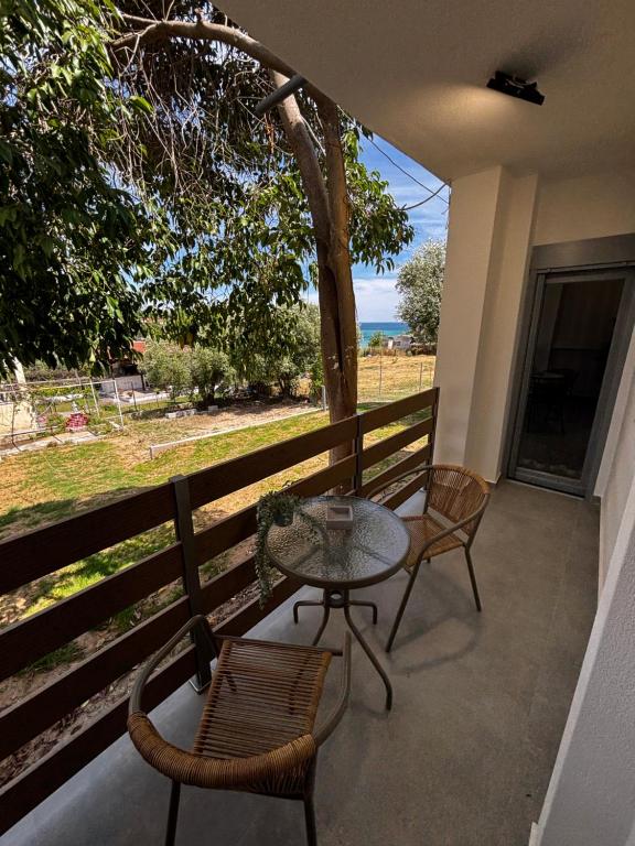 a patio with a table and chairs on a balcony at Summer Project Theros in Nea Kalikratia
