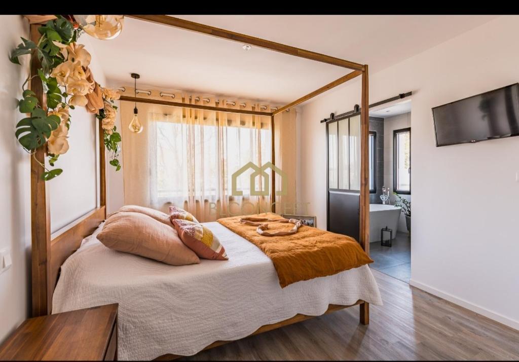 - une chambre avec un lit à baldaquin et des oreillers dans l'établissement Bassin d'Arcachon maison cozi, à La Celle-sous-Gouzon