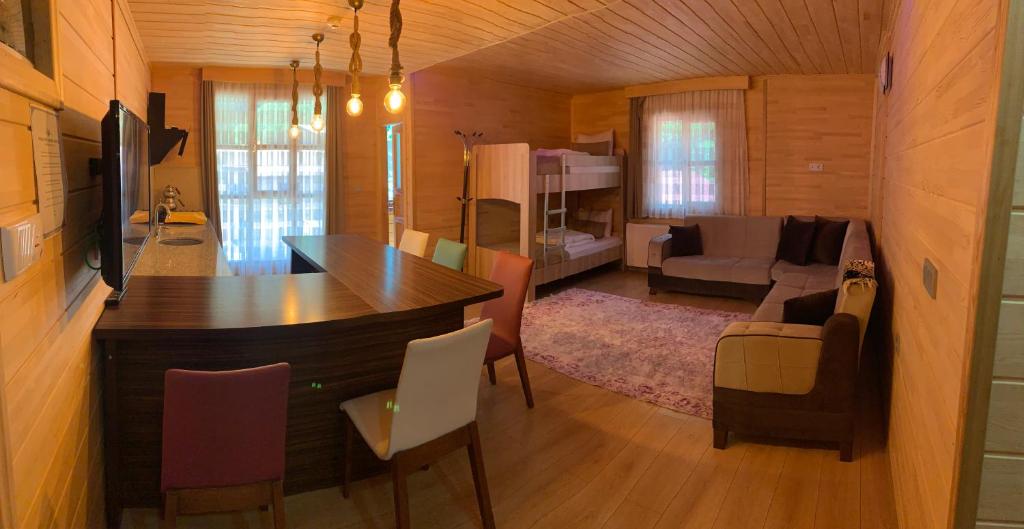 a kitchen and living room with a table and chairs at Bavul Suite Hotel in Uzungol