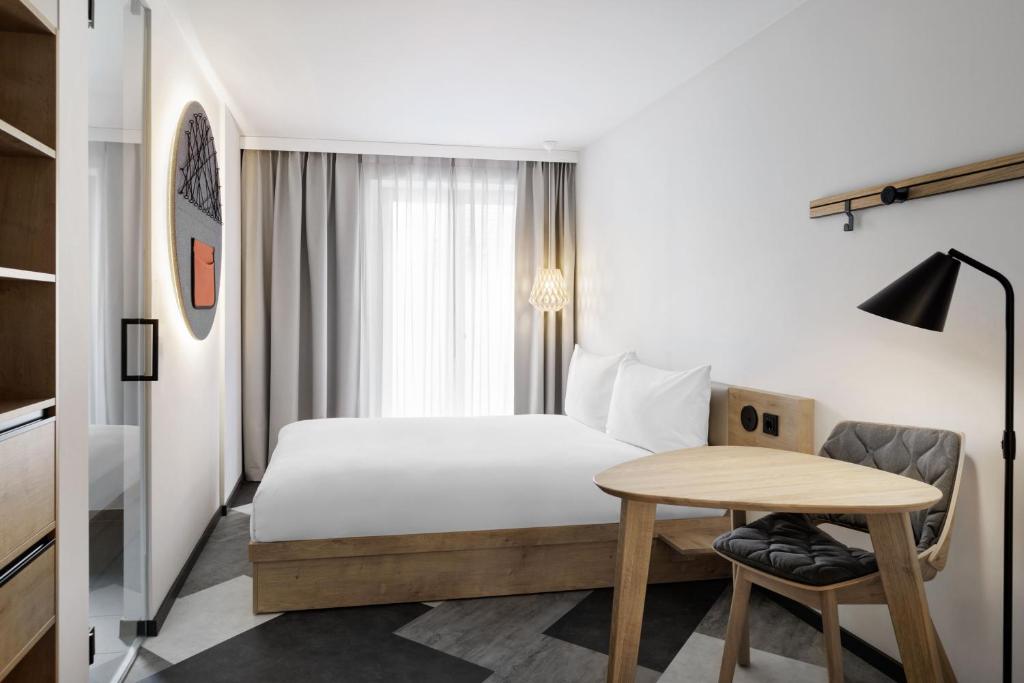 a hotel room with a bed and a table at Stay KooooK Munich City - NEW OPENING in Munich