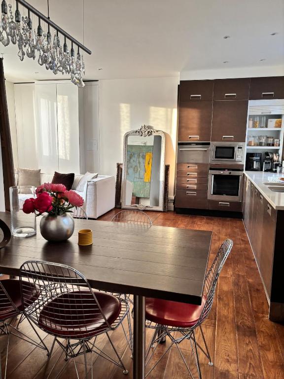 une cuisine et un salon avec une table et des chaises dans l'établissement Golden Triangle Champs-Élysées, à Paris