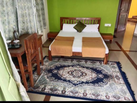 纳加奥恩veeras Homestay的一间卧室配有一张床、一张桌子和一张地毯。