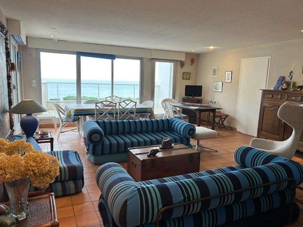 un salon avec des canapés bleus et une table dans l'établissement Appartement spacieux avec terrasses et parking à Royan - FR-1-494-73, à Royan