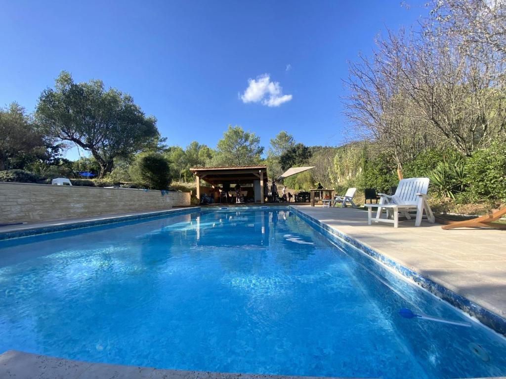 Villa 12 personnes au calme avec piscine في Puget-Ville: حمام سباحة كبير باللون الأزرق مع شرفة