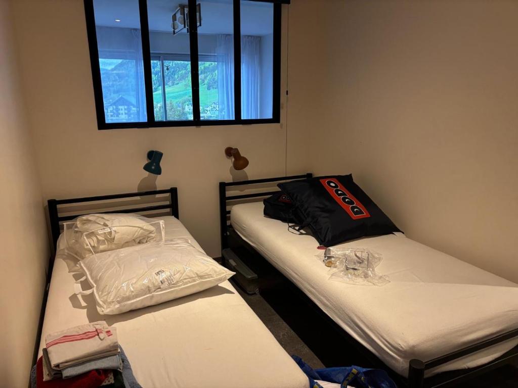 deux lits jumeaux dans une chambre avec fenêtre dans l'établissement Le Furon, à Prénatier