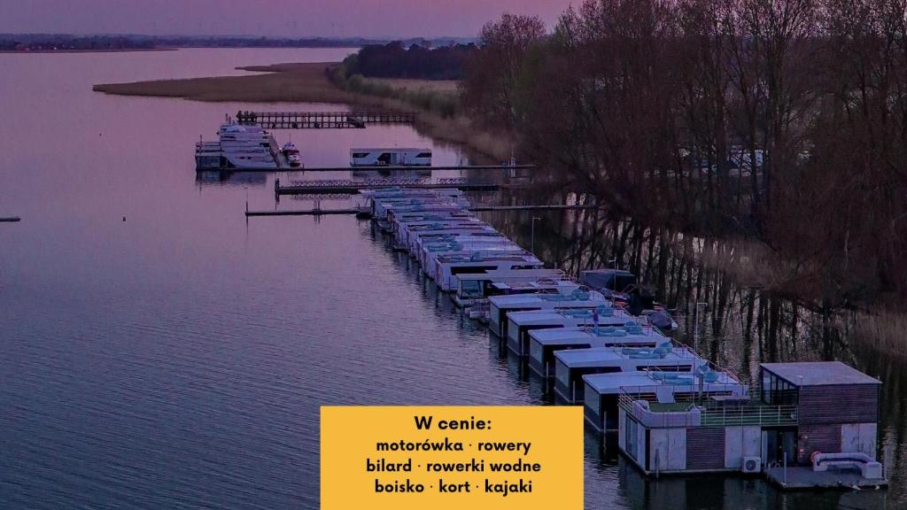 a marina with boats parked in the water at HT Houseboats - domki na wodzie - sauna, motorówka, rowerki wodne in Mielno