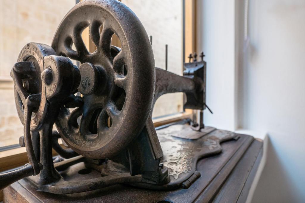 an old sewing machine sitting on top of a table at Kharmen A 1565s House with Seaviews in Birgu