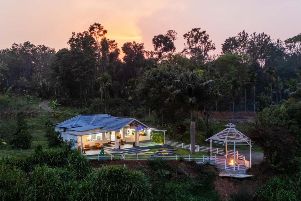 a house with a blue roof and a gazebo at StayVista at Kailaasa with Bonfire, Plunge Pool - Riverfront in Suntikoppa