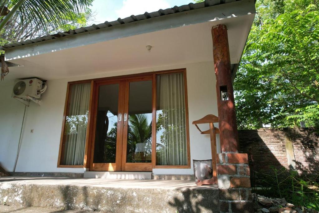 a house with wooden doors and windows at Coconut Scar Reef Homestay in Maluk