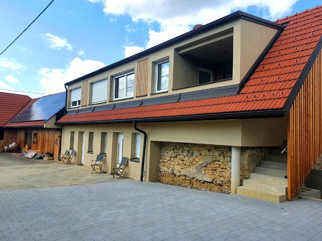 a house with a red roof and a garage at Sinnvoll - Ferienwohnung1 in Sankt Anna am Aigen