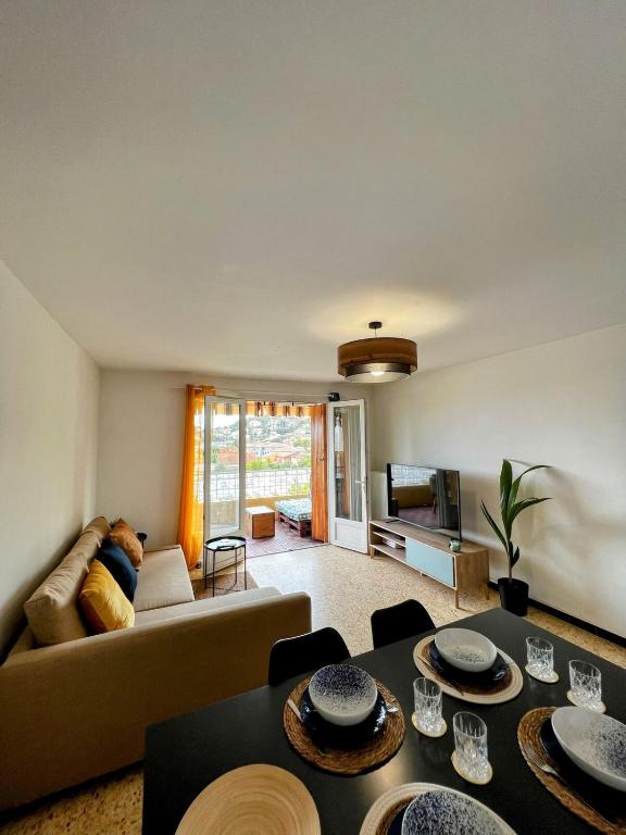 un salon avec un canapé et une table dans l'établissement Superbe T3 refait à neuf avec vue mer, à Carqueiranne
