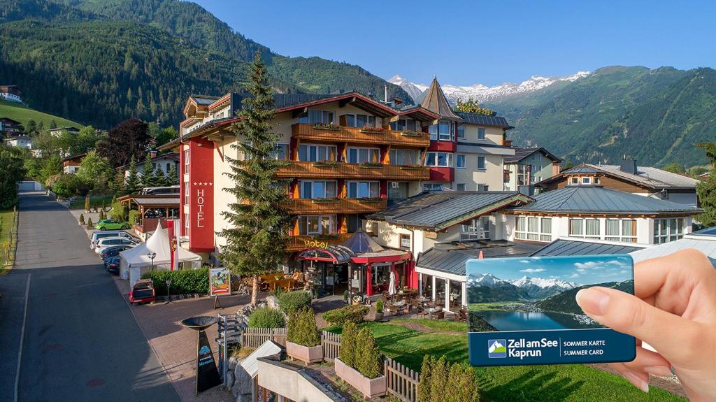 VÖTTER'S HOTEL in Kaprun - summer card included في كابرون: شخص يحمل صورة فندق