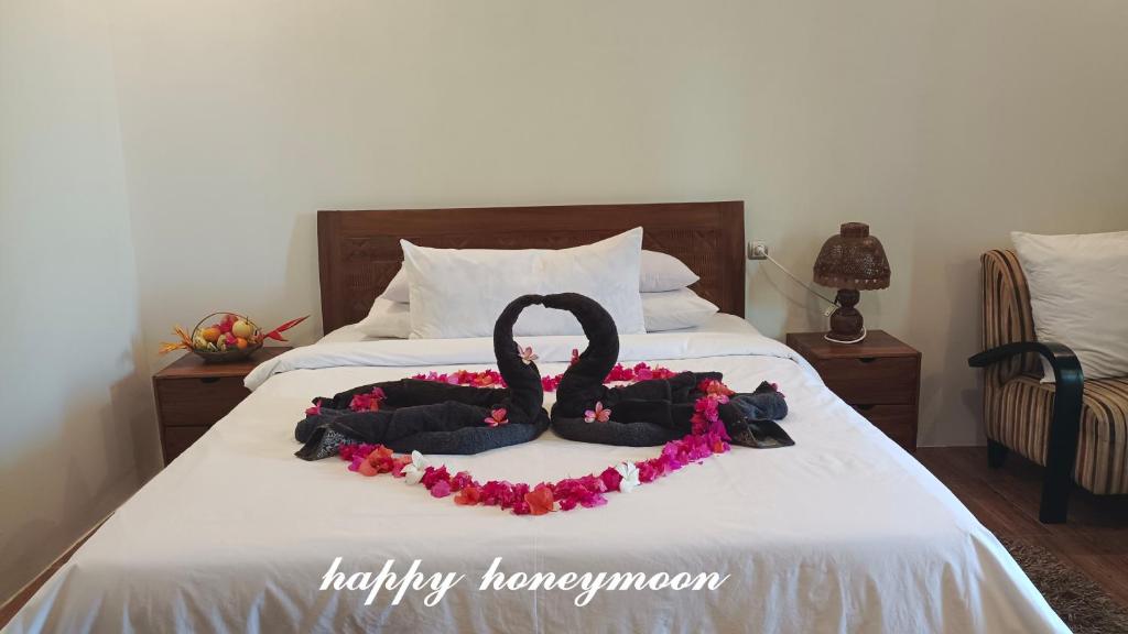 a bed with a black swan decoration on it at The luxe villas lombok in Kuta Lombok