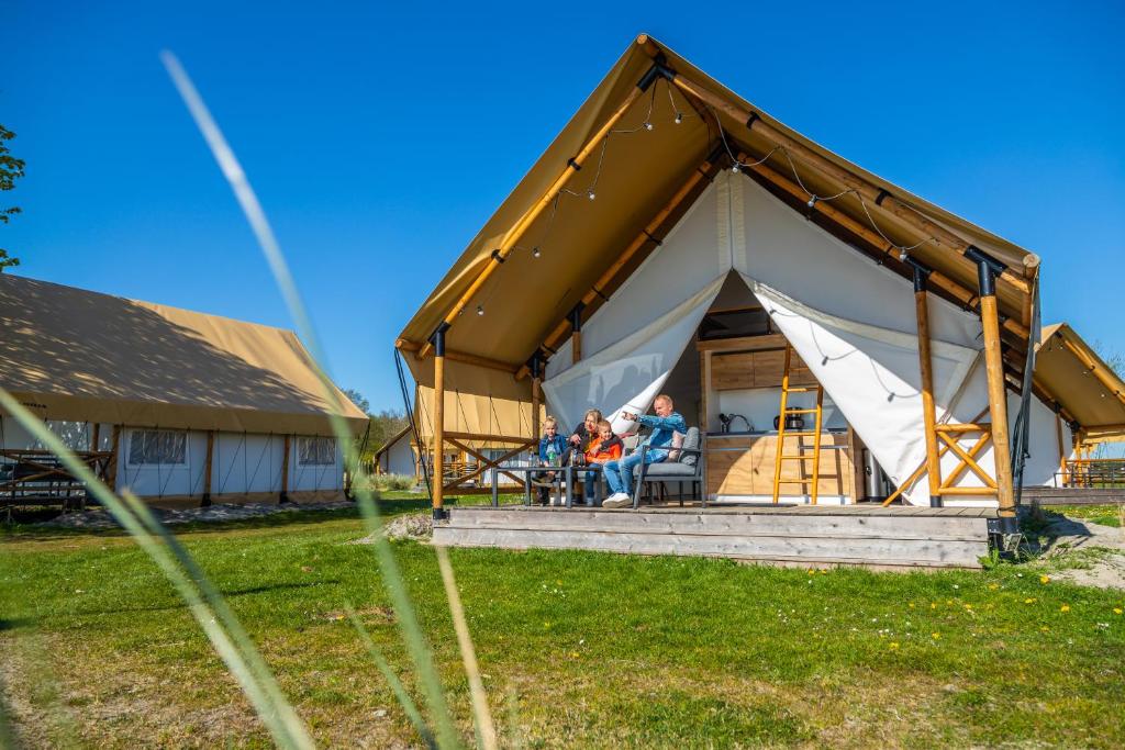 a family sitting inside of a large tent at Europarcs Zuiderzee in Biddinghuizen