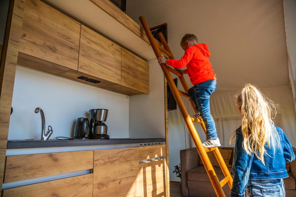 a man and a woman on a ladder in a room at Europarcs Zuiderzee in Biddinghuizen